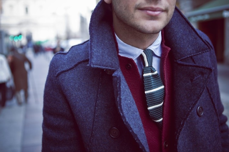 Knitted tie paired with a cardigan and coat 