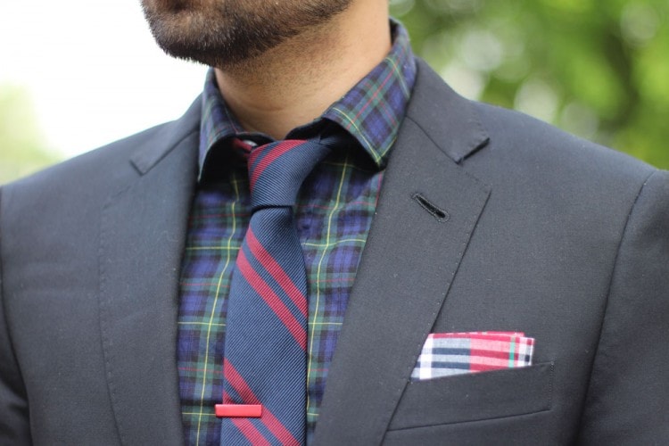 Charcoal blazer paired with a plaid shirt and striped tie 