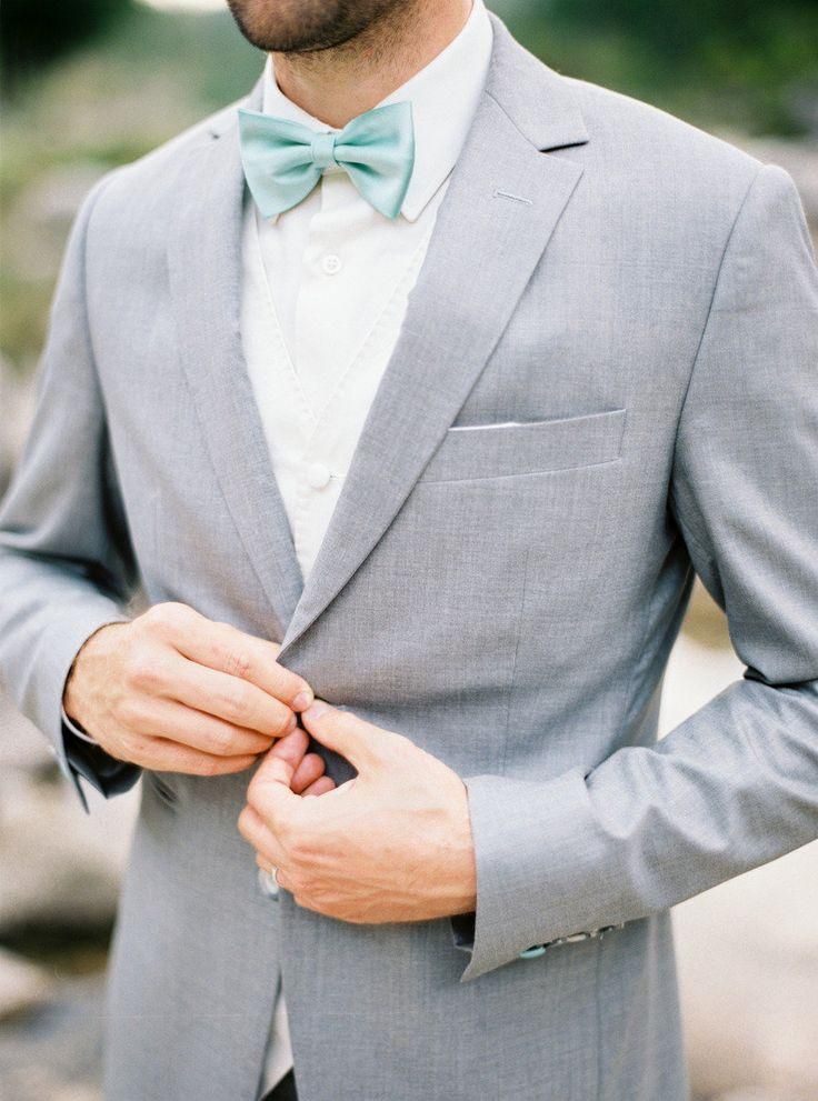 The combination of a classic gray suit with a pastel green bow tie 
