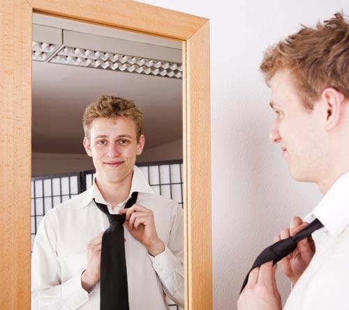 Tie a tie in front of the mirror 